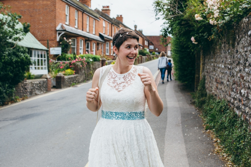 Photo of Brighton bride excited to see blue 1973 VW volkswagen camper van at rustic DIY wedding near Lewes